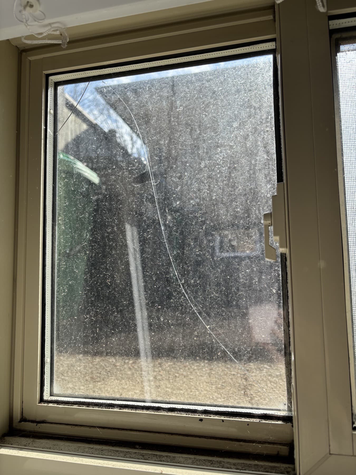 Cracked basement window glass before replacement