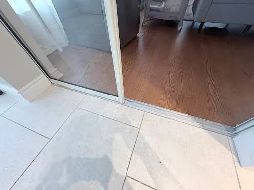 Lower track and threshold of a sliding patio door