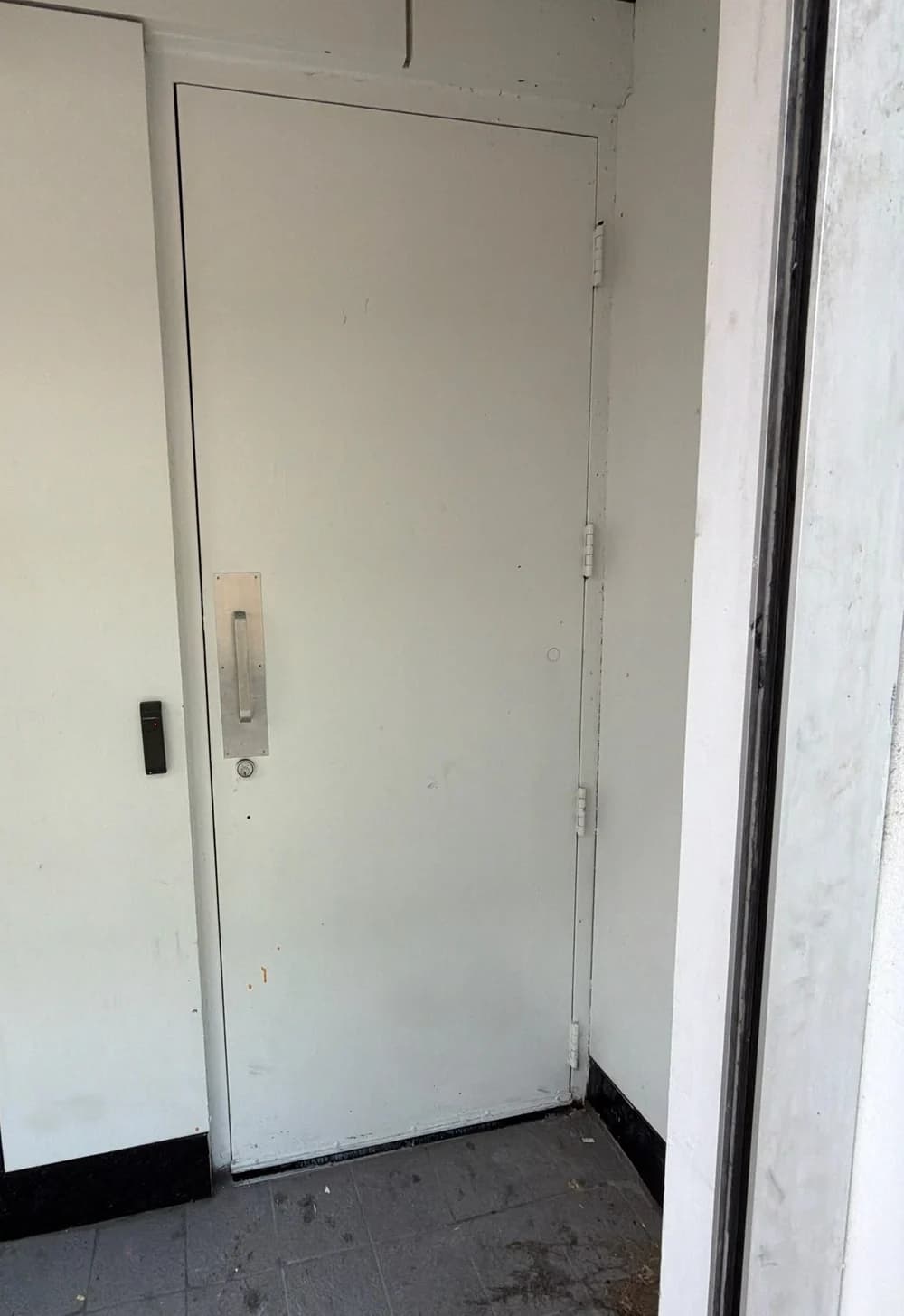 Existing white metal commercial entrance door in Downtown Toronto
